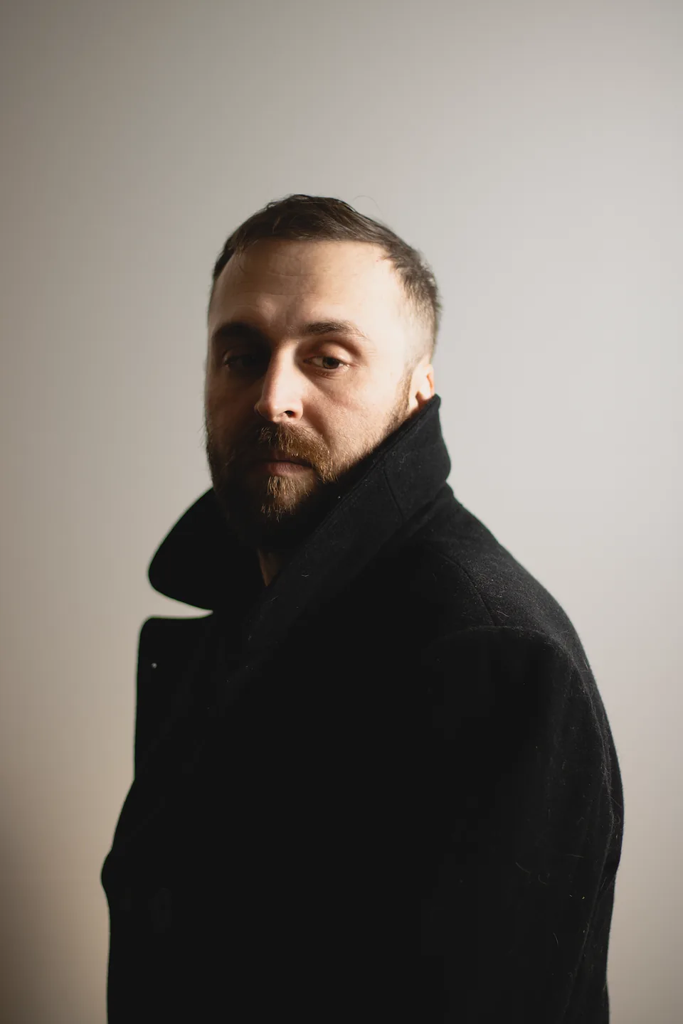 Man in a dark coat, dramatic half-light