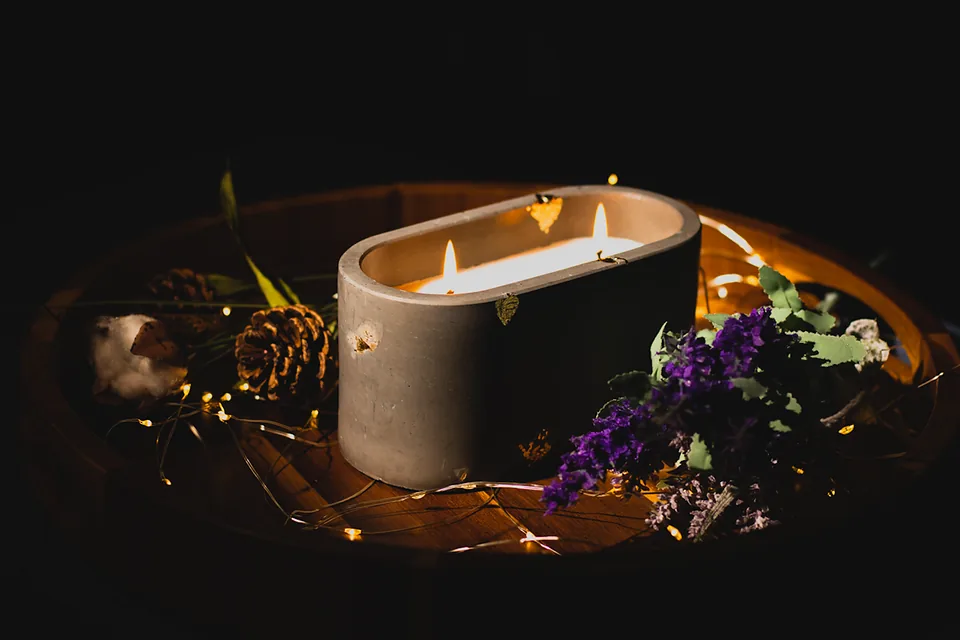 Lit candle with dried flowers and fairy lights