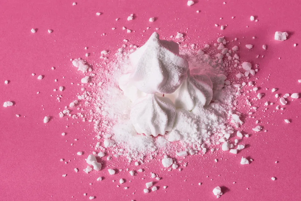 Suspiros and powdered sugar on hot pink