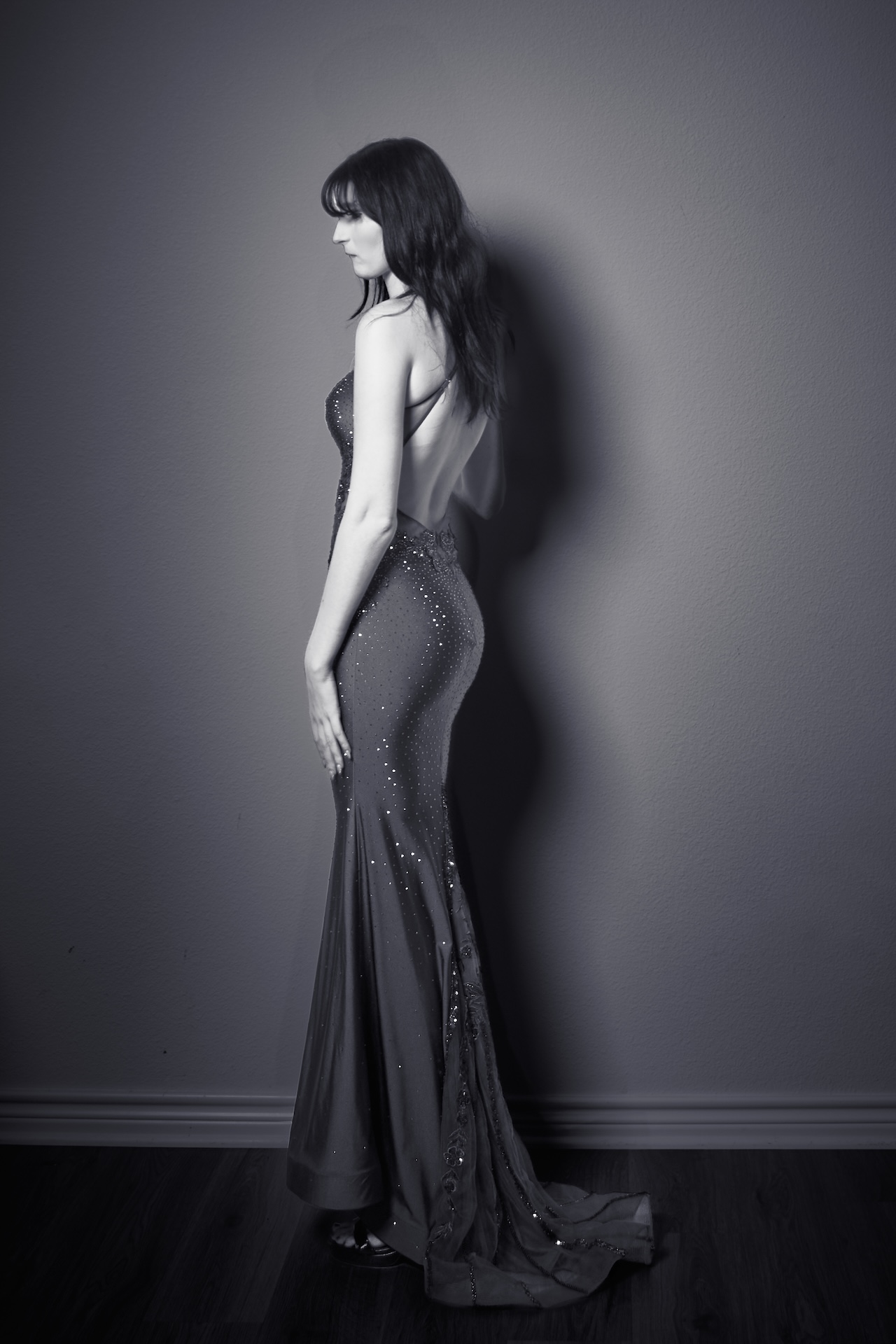 Classic black and white portrait of a woman in long dress with dramatic lighting