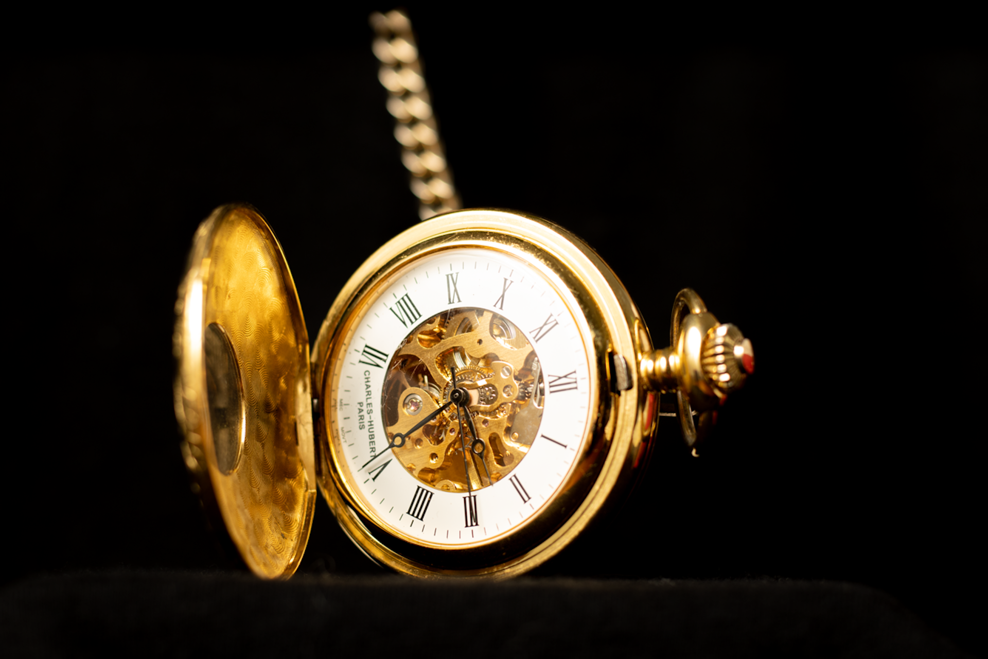 Gold pocket watch on black velvet