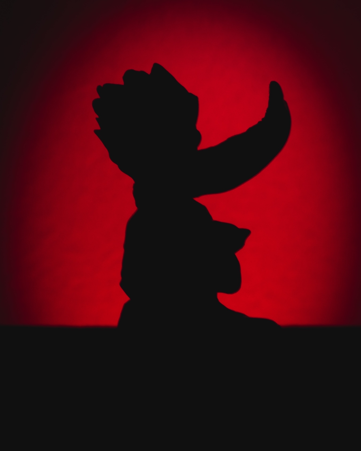 Figurine silhouette against deep red backlight
