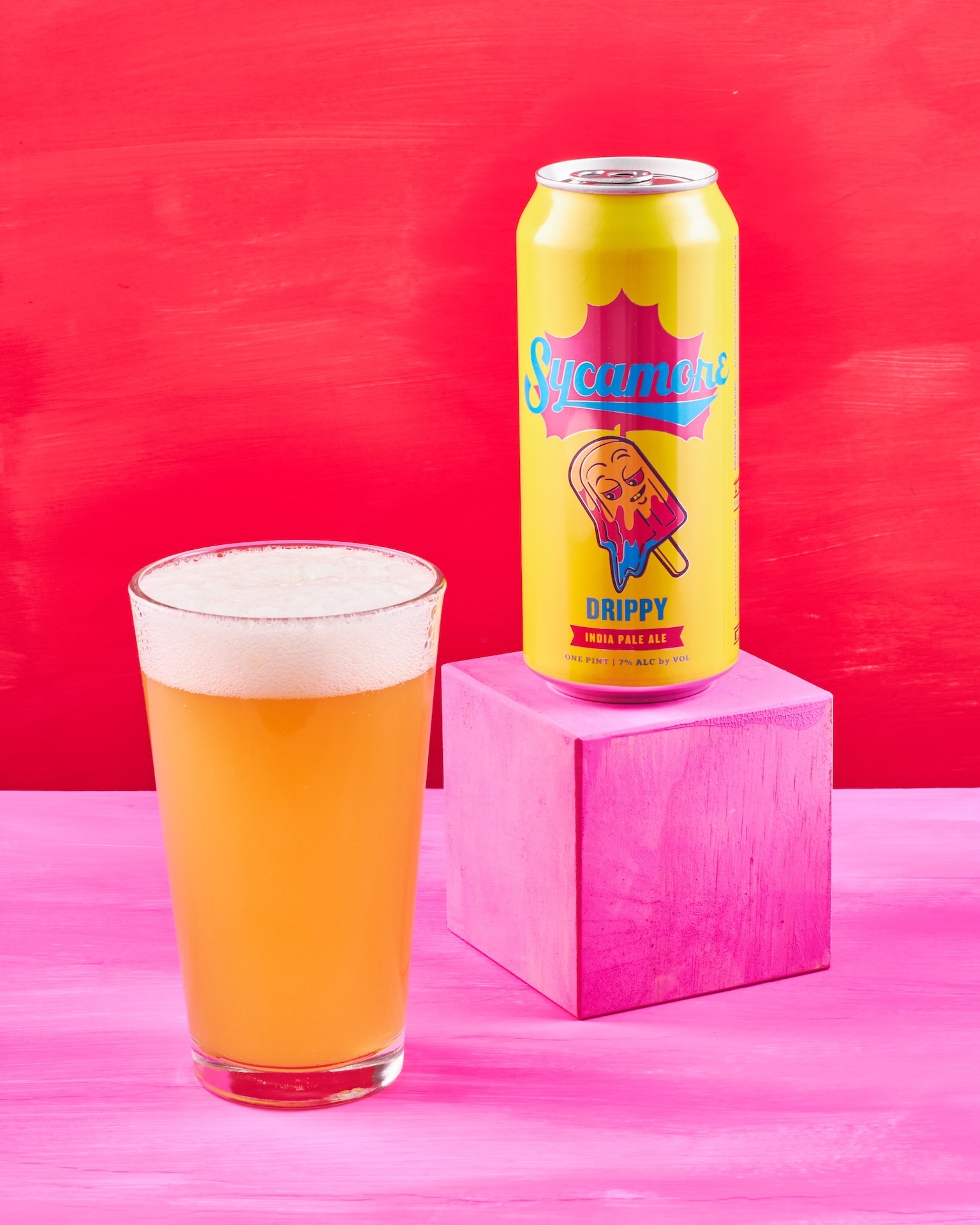 Sycamore Drippy IPA with glass on red and pink