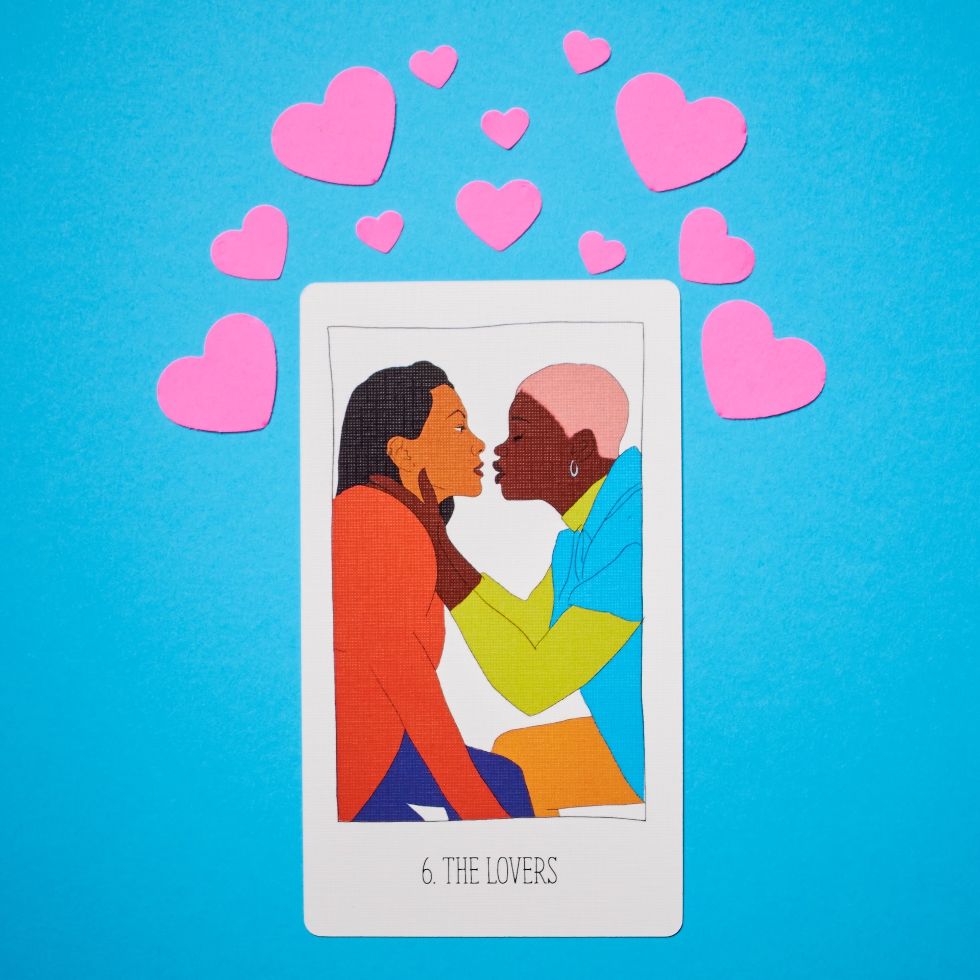 Tarot card The Lovers on blue background with pink hearts